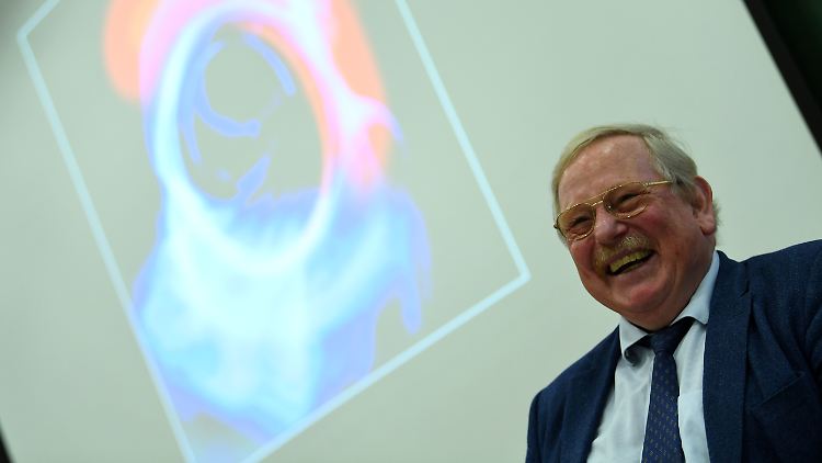 Reinhard Genzel vor einer Darstellung des Schwarzen Lochs in der Mitte der Milchstraße.