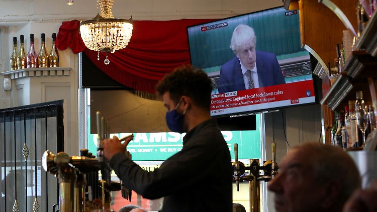 In einem Pub in Liverpool zapft der Barkeeper noch schnell ein Bier, während Premier Johnson die Corona-Ampel vorstellt.