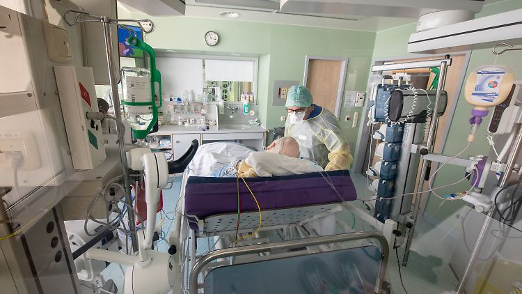 Ein Patient mit Corona-Infektion liegt im isolierten Intensivbett-Zimmer.