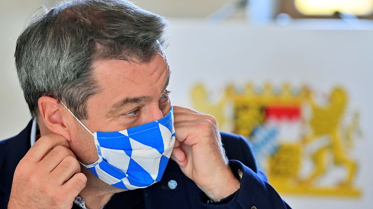 Söder trägt blau-weiße Maske, wünscht aber einen schwarz-rot-goldenen Plan.  
