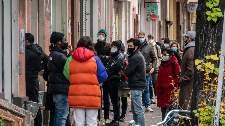 Vor einer Arztpraxis in Berlin-Neukölln warten viele Menschen auf einen Corona-Test. 