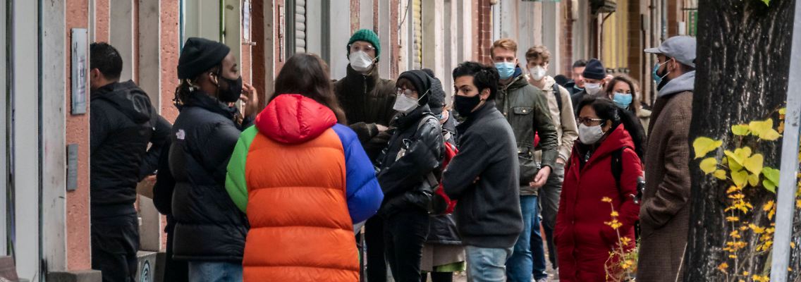 Vor einer Arztpraxis in Berlin Neukölln warten zahlreiche Menschen auf einen Test.