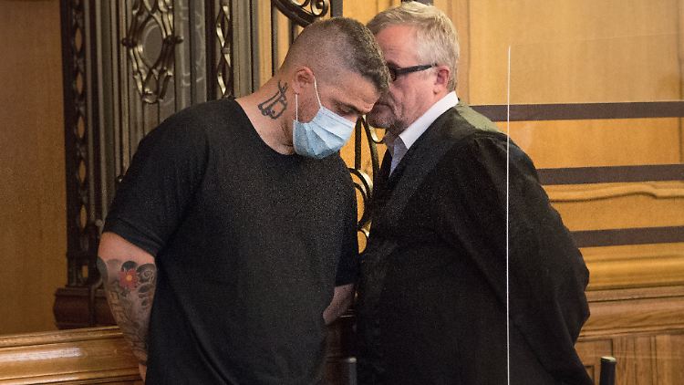 Bushido (l.) berät sich vor Gericht mit seinem Anwalt.