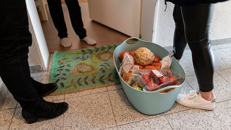 Mitarbeiterinnen des Malteser Hilfsdienstes stehen mit Lebensmitteln vor einer Haustür.