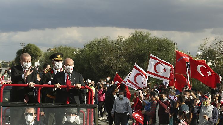 Der türkische Präsident Erdogan und der Präsident von Nordzypern, Tatar, winken ihren Anhängern zu.