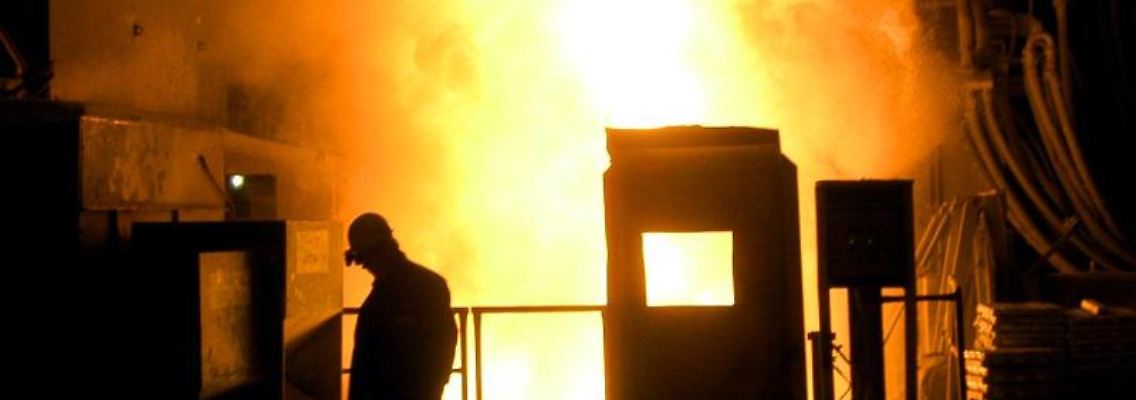 Ein Arbeiter geht im Werk der Lech-Stahlwerke an einem glühenden Schmelzofen vorbei. Foto: Stefan Puchner/dpa/Archivbild