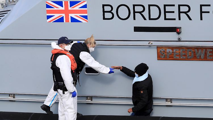 Ein Flüchtling wird von britischen Grenzstreitkräften aufgenommen und in Dover an Land gebracht.