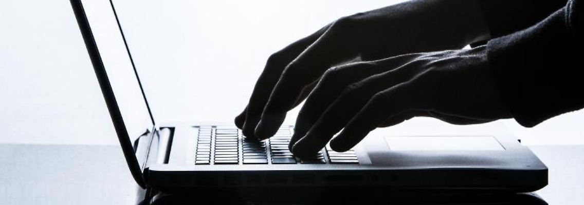 Ein Mann tippt auf einer Tastatur eines Laptops. Foto: Silas Stein/dpa/Symbolbild