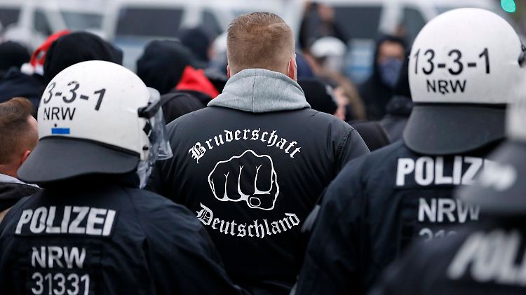 Bei einer Querdenken-Demo in Düsseldorf kesseln Polizisten einige Hooligans ein. 