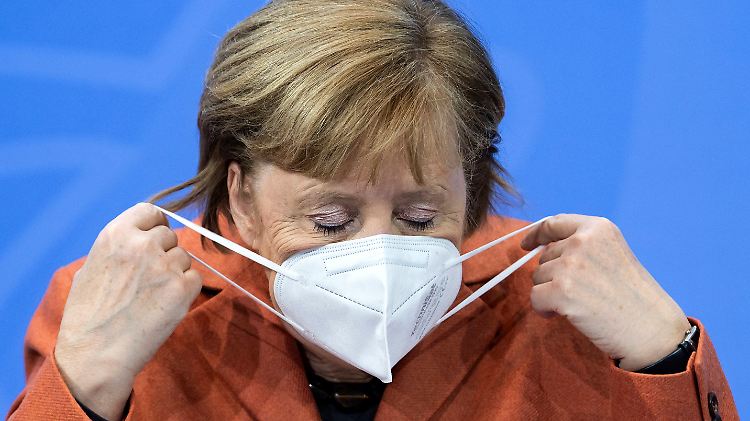 Zu Beginn der Pressekonferenz legt Merkel ihre Mund-Nase-Maske ab.