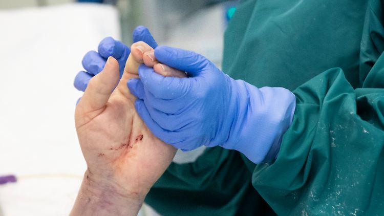 Eine italienische Intensivschwester hält einem Corona-Patienten die Hand.