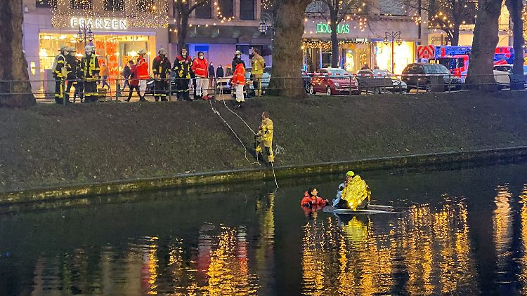 Einsatzkräfte halfen dem Autofahrer, der in den Kö-Graben gefahren war und sich auf das Dach seines Wagens retten konnte.