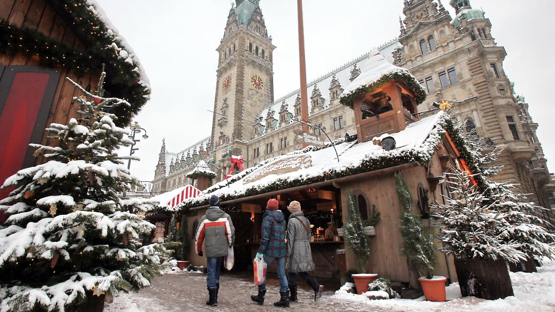 Verschneiter Weihnachtsmarkt vor dem Rathaus in Hamburg.
