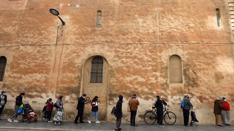An Weihnachten stellen sich Menschen vor der Kapuzinerkirche in Palma de Mallorca für ein Wohltätigkeitsessen an.