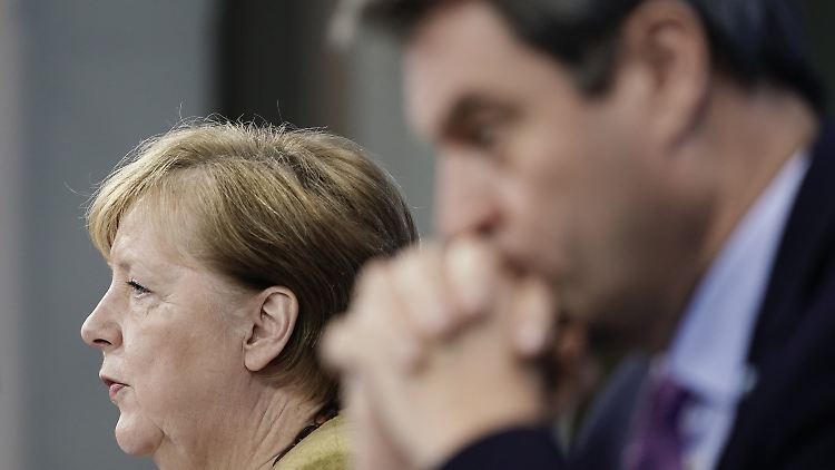 Bundeskanzlerin Merkel stellt am Dienstagabend die Ergebnisse der Bund-Länder-Konferenz vor. Im Vordergrund sitzt Bayerns Ministerpräsident Söder.