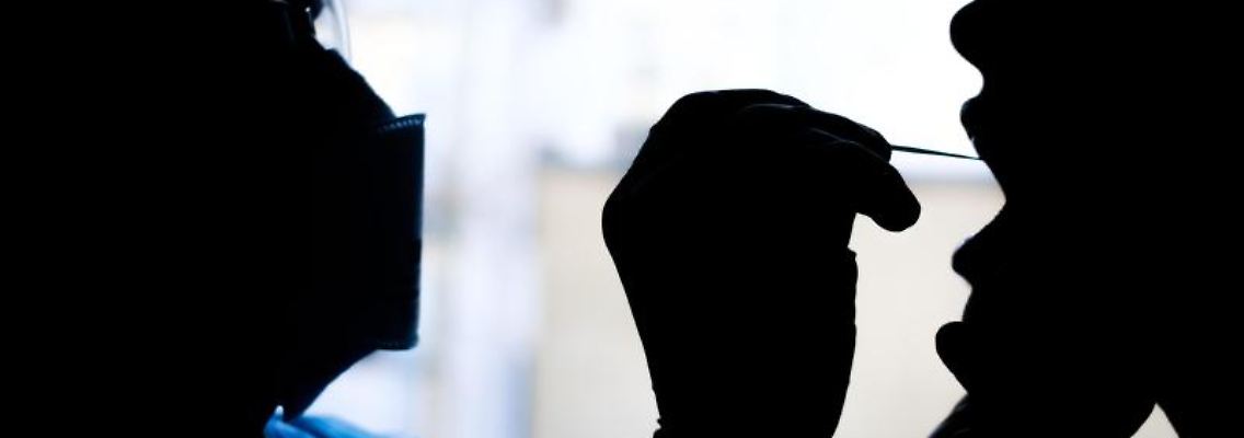 Ein Facharzt für Allgemeinmedizin nimmt bei einer Patientin einen Rachenabstrich für einen Covid-19 Schnelltest. Foto: Ole Spata/dpa/Archiv