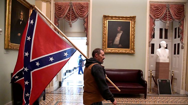 Ein Trump-Anhänger marschiert mit der Konföderierten-Flagge durchs Kapitol.