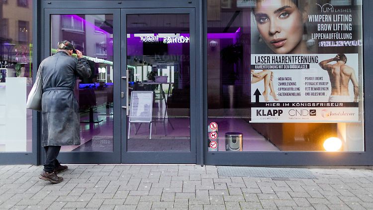 Ein Mann schaut in das geschlossene Ladenlokal des Kosmetikstudios "Mr & Mrs Perfect". Der Krefelder Inhaber wollte heute eigentlich sein Kosmetikstudio trotz Lockdown wieder öffnen.