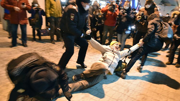 Polizisten halten am Terminal des Flughafens Moskau-Wnukowo eine Person fest, die auf die Ankunft des Oppositionsführers Nawalny wartet.