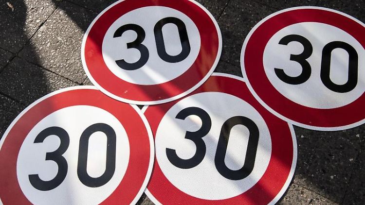 Neue Tempo-30-Schilder liegen auf dem Boden.