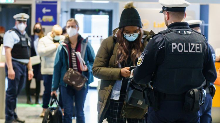 Bundespolizisten kontrollieren Passagiere am Frankfurter FLughafen.