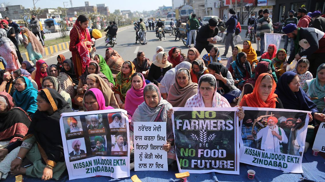 Aktivistinnen verschiedener Parteien blockieren mit einer Sitzblockade die Fahrbahn der Autobahn Jammu-Pathankot.