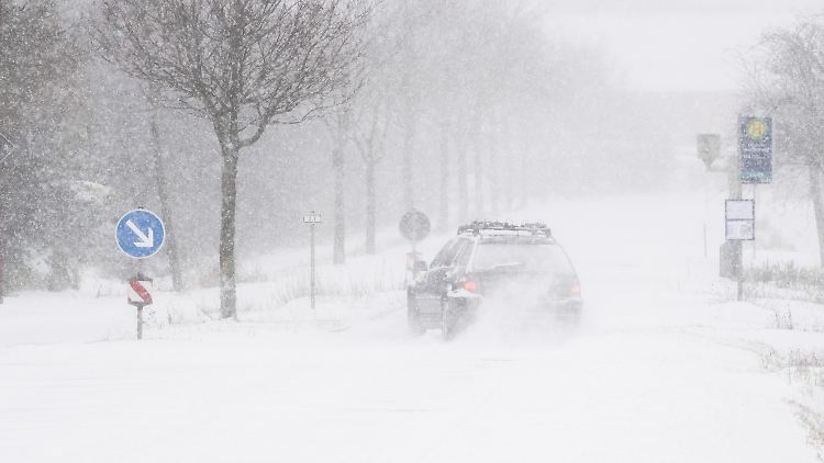 In Ingeln-Oesselse (Niedersachsen) kämpft ein Autofahrer mit der zugeschneiten Fahrbahn. 