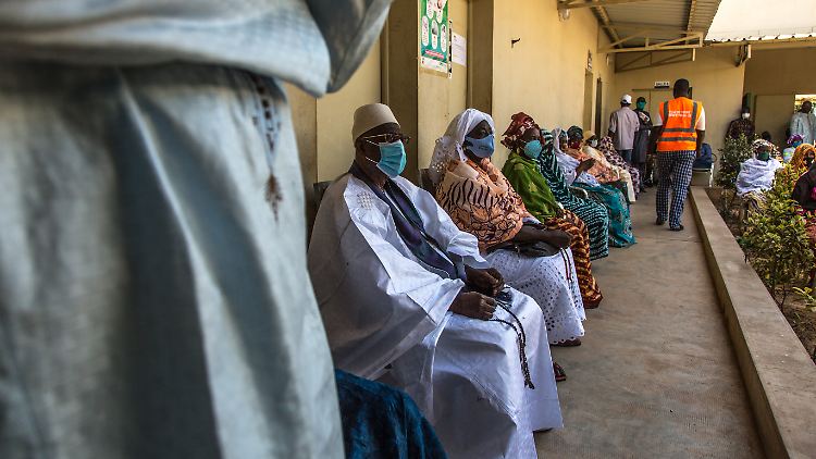 Menschen  im Senegal warten auf die Verteilung von Lebensmitteln.