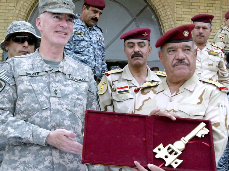 Der irakische Generalleutnant Abboud Qanbar (r) zeigt einen symbolischen Schlüssel, den ihm Oberst Daniel Bolger (l) bei einer Zeremonie aus Anlass des Abzugs der US-Truppen aus den Städten und Dörfern des Irak in Bagdad überreicht (Archivfoto vom 29. Juni 2009).