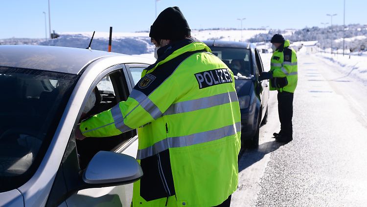 Zwei Bundespolizisten kontrollieren an der deutsch-tschechischen Grenze die Personalien.
