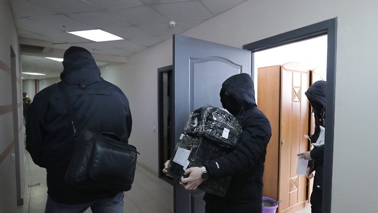 Vermummte Polizisten beschlagnahmen Geräte im Büro des belarussischen Journalistenverbands BAJ in Minsk.