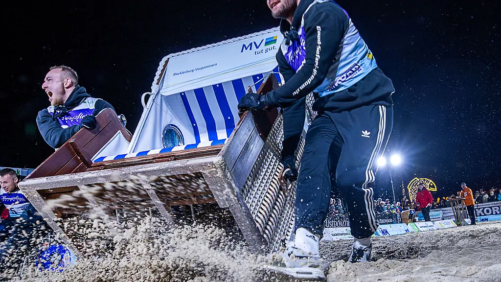 Die-Zweierteams-muessen-einen-Strandkorb-ueber-die-20-Meter-lange-Strecke-am-Ostseestrand-ins-Ziel-schleppen