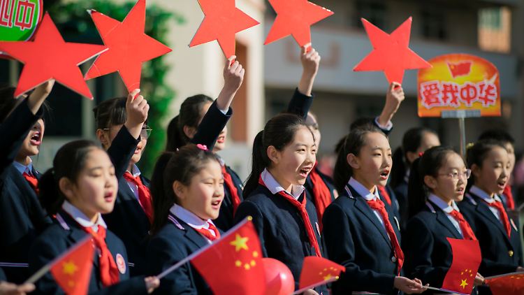 Assimilation erfolgreich: Schülerinnen in Hohhot, der Provinzhauptstadt der Inneren Mongolei, halten im Februar 2019 chinesische Flaggen in den Händen und singen ein Lied namens "Ich und mein Land".