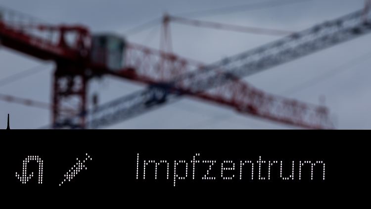 In Köln weist ein Schild den Weg zum Impfzentrum.
