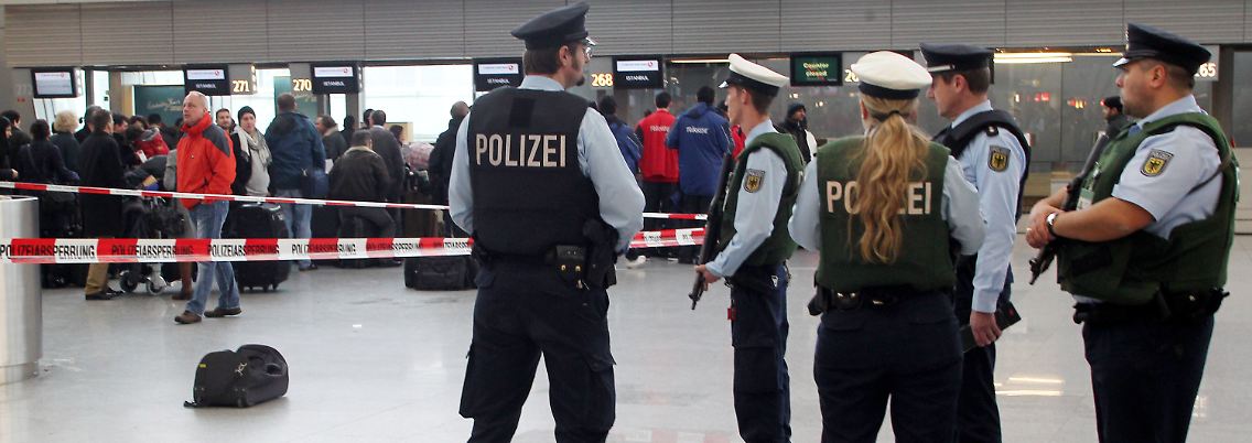 Polizisten sichern auf dem Düsseldorfer Flughafen ein herrenloses Gepäckstück.