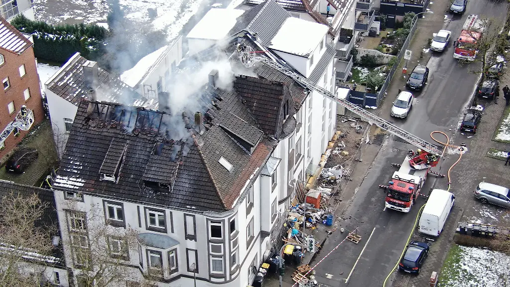 Ein-Feuer-ist-in-einem-Dachgeschoss-ausgebrochen-Erwachsene-und-Kinder-werden-ueber-Drehleitern-gerettet