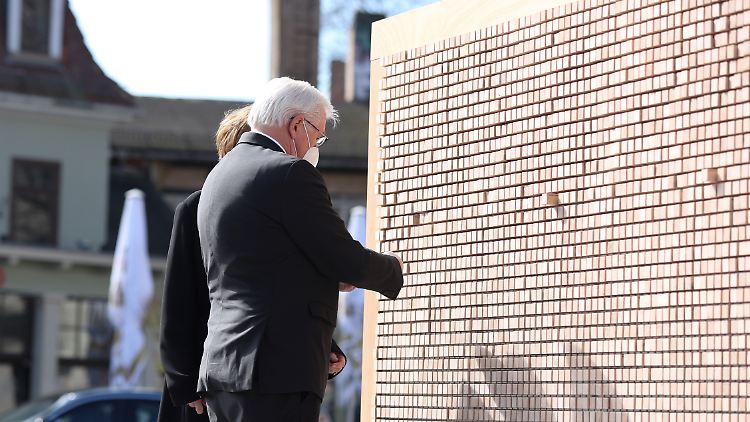 Steinmeier und seine Frau Elke Büdenbender stehen vor einer Wand mit Zitaten von Menschen, die in Buchenwald von den Nazis getötet wurden.