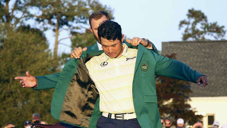 Vorjahressieger Dustin Johnson kleidet Hideki Matsuyama in das Kleid eines Masters-Siegers.