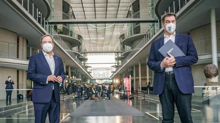 Markus Söder (CSU, r) steht neben Armin Laschet (CDU, l). Foto: Michael Kappeler/dpa