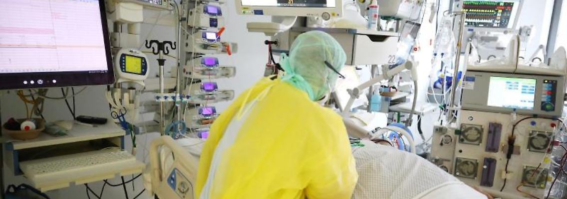 Ein Arzt untersucht einen Patienten auf der Covid-19-Intensivstation im SRH Waldklinikum in Gera. Foto: Bodo Schackow/dpa-zentralbild/dpa