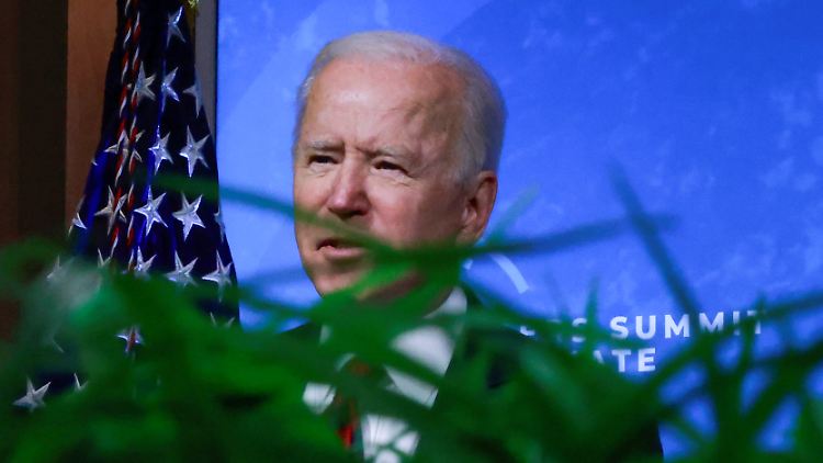 Die digitale Konferenz verfolgt Biden an einem runden Tisch mit viel Grün in der Mitte.