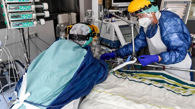 Pfleger in Schutzausrüstung versorgen einen Covid-19-Patienten auf der Intensivstation des Sint-Trudo Krankenhauses.