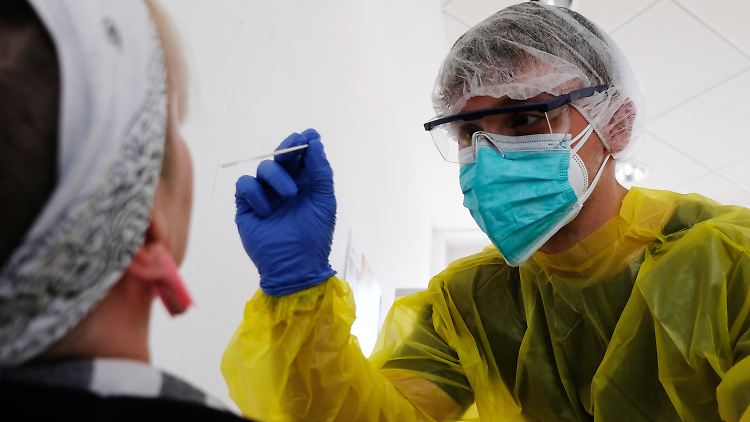 In einer mobilen Teststation wird eine Frau auf das Coronavirus getestet.