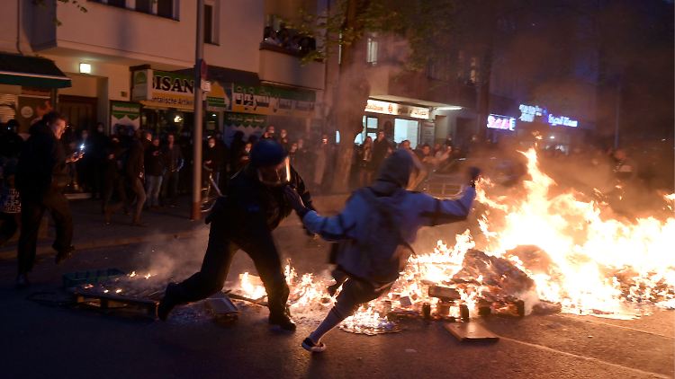 Polizei und Teilnehmer geraten bei einem Feuer am Rande des Demonstrationszugs aneinander.