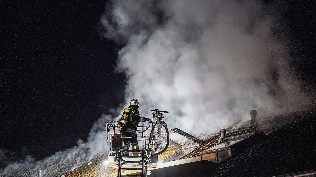 Ein-Feuerwehrmann-loescht-den-Brand-in-einem-Mehrfamilienhaus