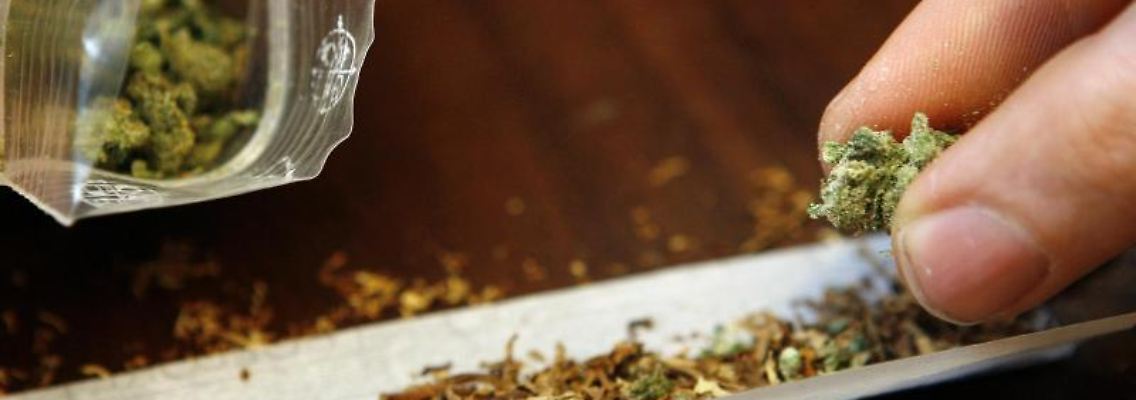 Ein Mann dreht sich einen Joint mit Cannabis. Foto: Daniel Karmann/dpa/Archivbild