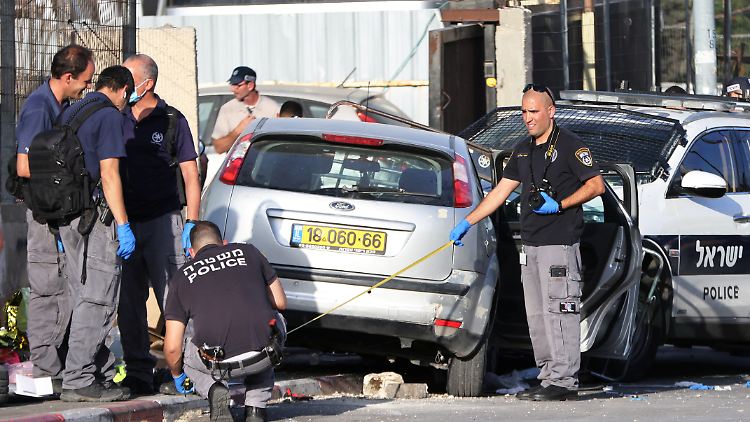 Sicherheitskräfte untersuchen das Auto, mit dem mehrere Polizisten verletzt wurden.