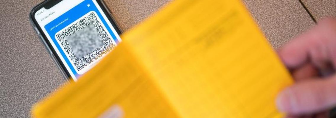 Ein Smartphone mit dem QR Code auf dem Tisch einer Apotheke. Foto: Oliver Dietze/dpa