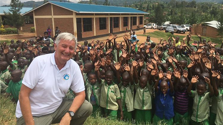 Reiner Meutsch mit Kindern vor einer neu gebauten Schule in Sure, Ruanda.