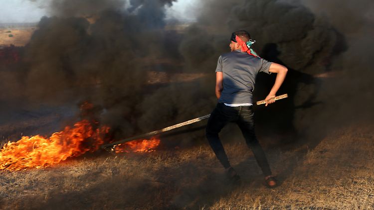 Aus Protest gegen den Flaggenmarsch ultrarechter Israelis in Jerusalem verbrennen palästinensische Jugendliche Autoreifen an der Grenze zu Israel.